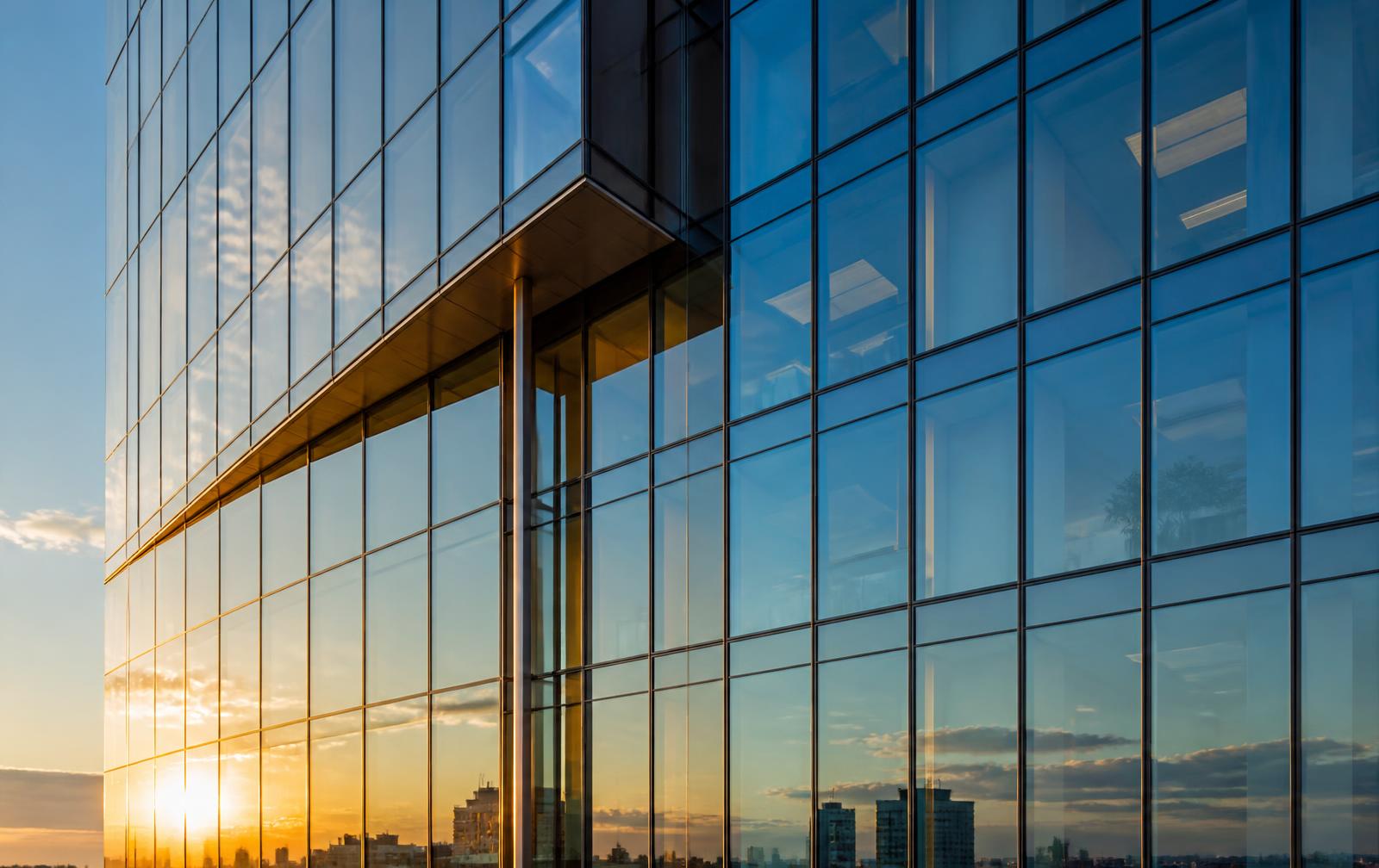 Modern commercial curtain wall glass facade at golden hour